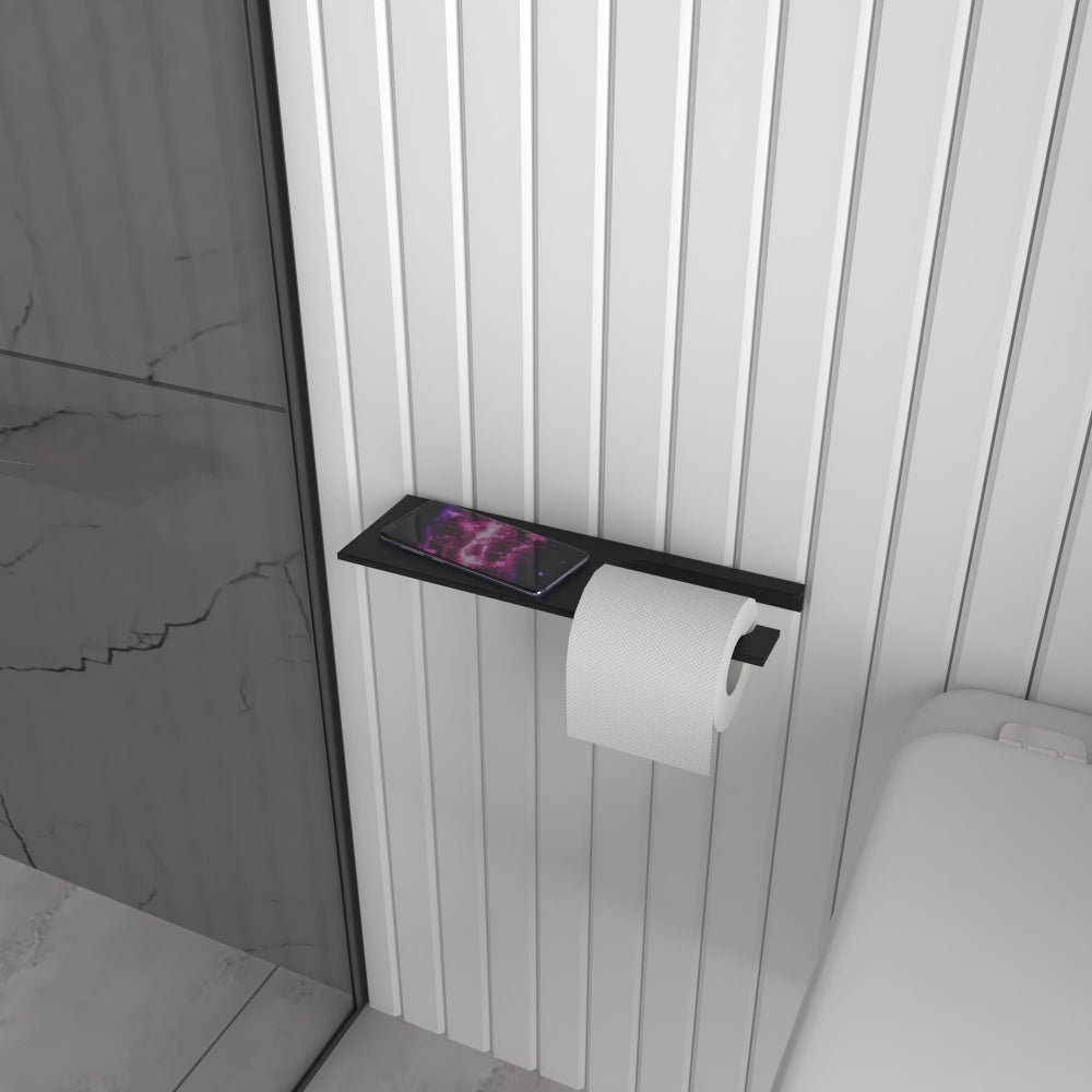 A black multifunctional bathroom shelf with a built-in toilet paper holder mounted on a marble-patterned wall, showing the in-use roll on the lower bar and the upper shelf for accessories.