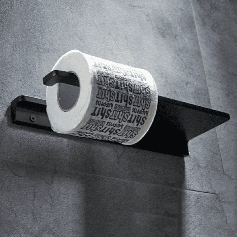 A black multifunctional bathroom shelf with a toilet paper holder mounted on a gray wall, holding a roll of toilet paper with printed text.