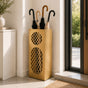 Gold oval mesh metal umbrella stand in contemporary entryway with warm minimalist decor