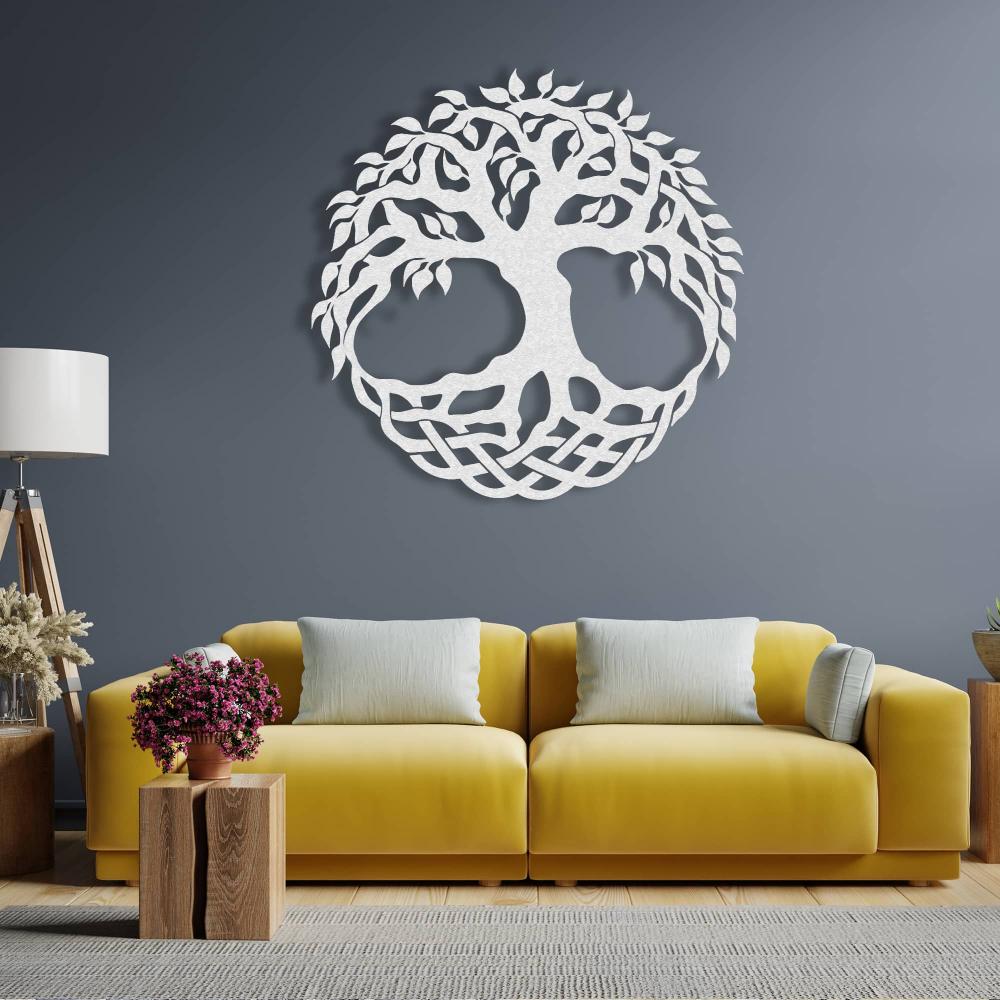 White metal tree of life wall art featuring intricate branches and a Celtic-inspired base design, elegantly displayed on a dark blue wall above a bright yellow sofa in a contemporary living room.