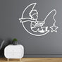 A white metal wall art of a little prince sitting on a crescent moon and fishing a star, mounted on a gray wall above a modern white nightstand.