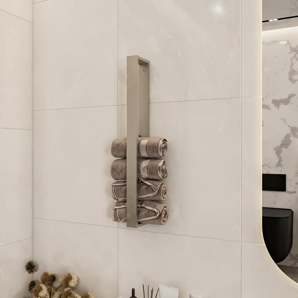 A Satine Nickel vertical towel rack mounted on a glossy tiled bathroom wall, holding neatly rolled towels in light brown tones, blending elegance with practicality.