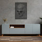 Black skull-themed abstract wall art featuring wavy lines, mounted on a textured gray wall above a modern light blue cabinet with wooden accents. The setting includes a glass vase with dried plants and a minimalistic decor style.