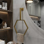 Modern bathroom featuring a minimalist design with a gold wall-mounted hexagonal towel ring. The hexagonal frame adds an elegant touch to the decor, blending seamlessly with the neutral tones and sleek shelving unit.
