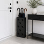 Tall black metal umbrella stand with multi-umbrella pattern beside console table in modern hallway