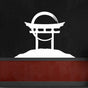 A white Torii gate metal wall art mounted on a black wall with a red accent panel, creating a bold visual contrast.