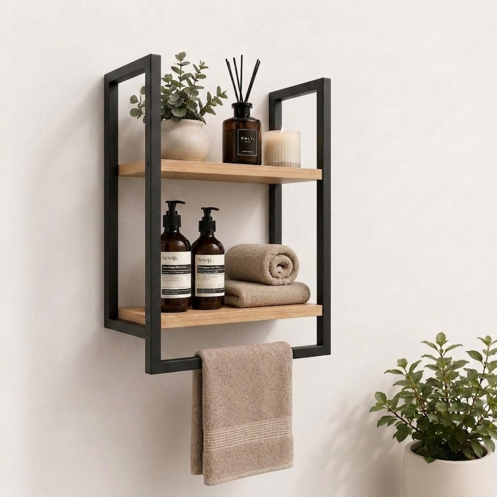 Black wall mounted 2-tier bathroom shelf with towel bar holding bathroom bottles, towels, and decor.