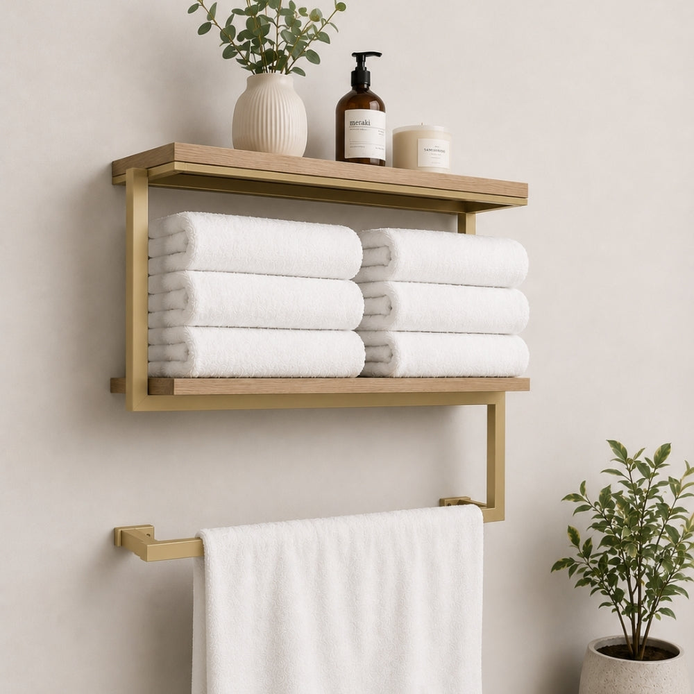 Gold wall mounted 2-tier towel shelf with towel bar holding folded towels and bathroom decor.