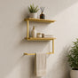 Gold wall mounted 2-tier towel shelf with towel bar holding towels and bathroom decor.