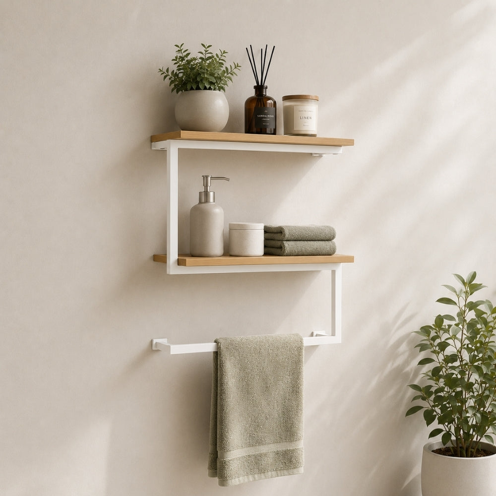 White wall mounted 2-tier towel shelf with towel bar holding towels and bathroom decor.