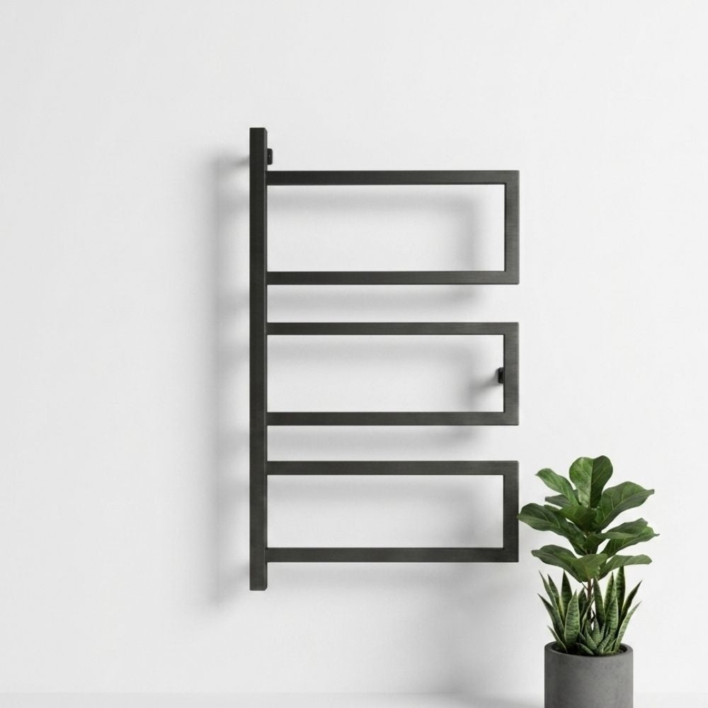 Black wall mounted 3-tier towel rack in a minimal bathroom scene with potted plant.