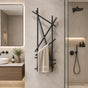 Black wall mounted branch towel rack with towel in a modern bathroom.