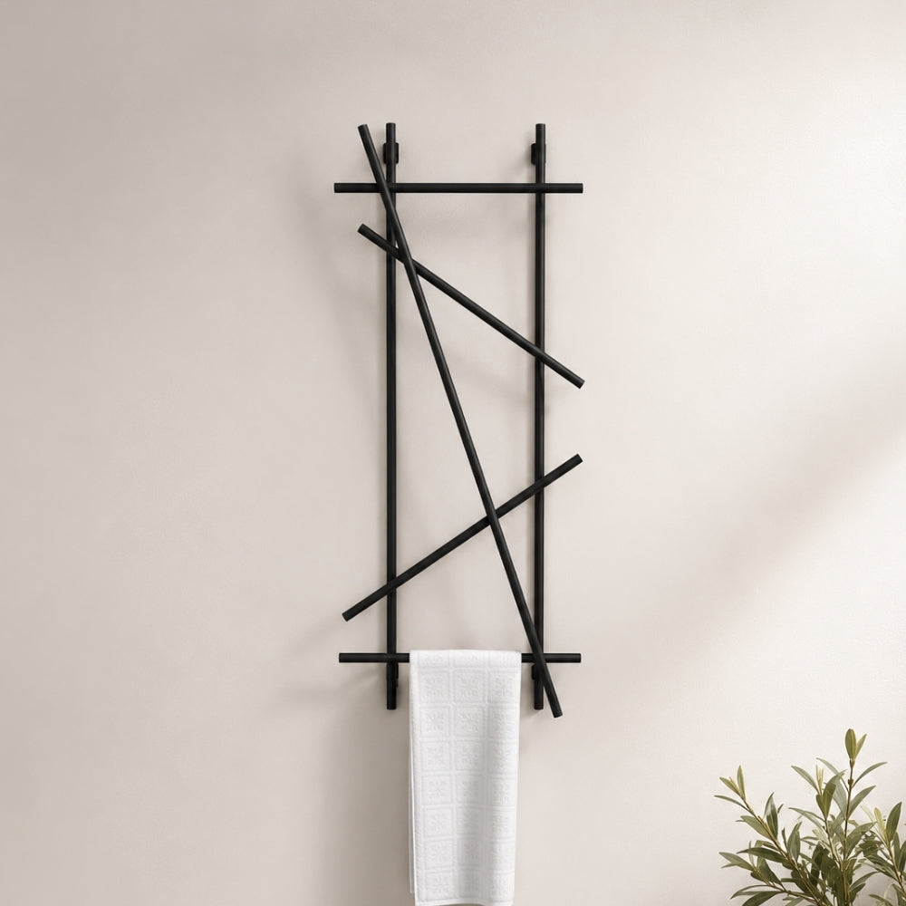 Black wall mounted branch towel rack and coat rack holding a white towel on a neutral bathroom wall.