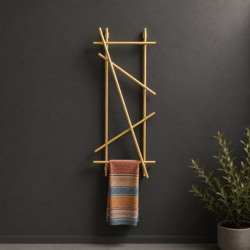 Gold wall mounted branch towel rack and coat rack holding a patterned towel on a dark wall.