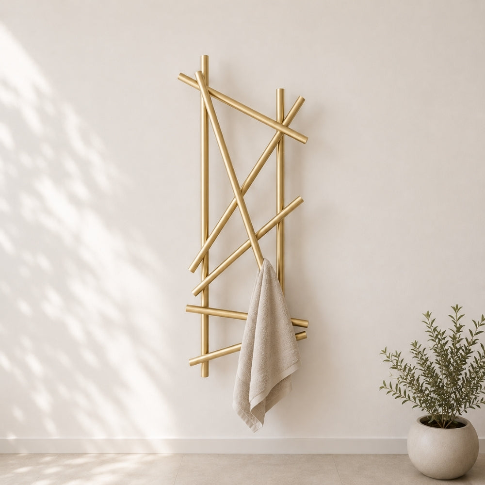Gold wall mounted branch towel rack holding a beige towel on a light bathroom wall.