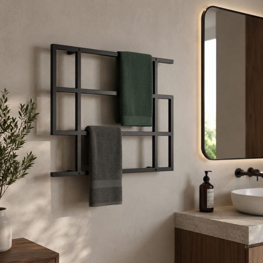 Black wall mounted geometric towel rack holding green and gray towels beside a modern bathroom vanity.