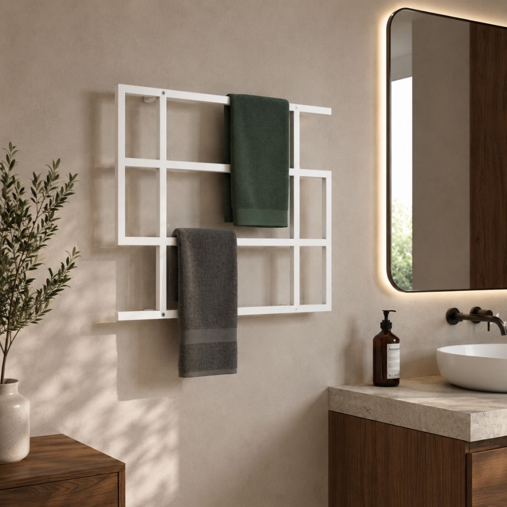 White wall mounted geometric towel rack holding green and gray towels beside a modern bathroom vanity.