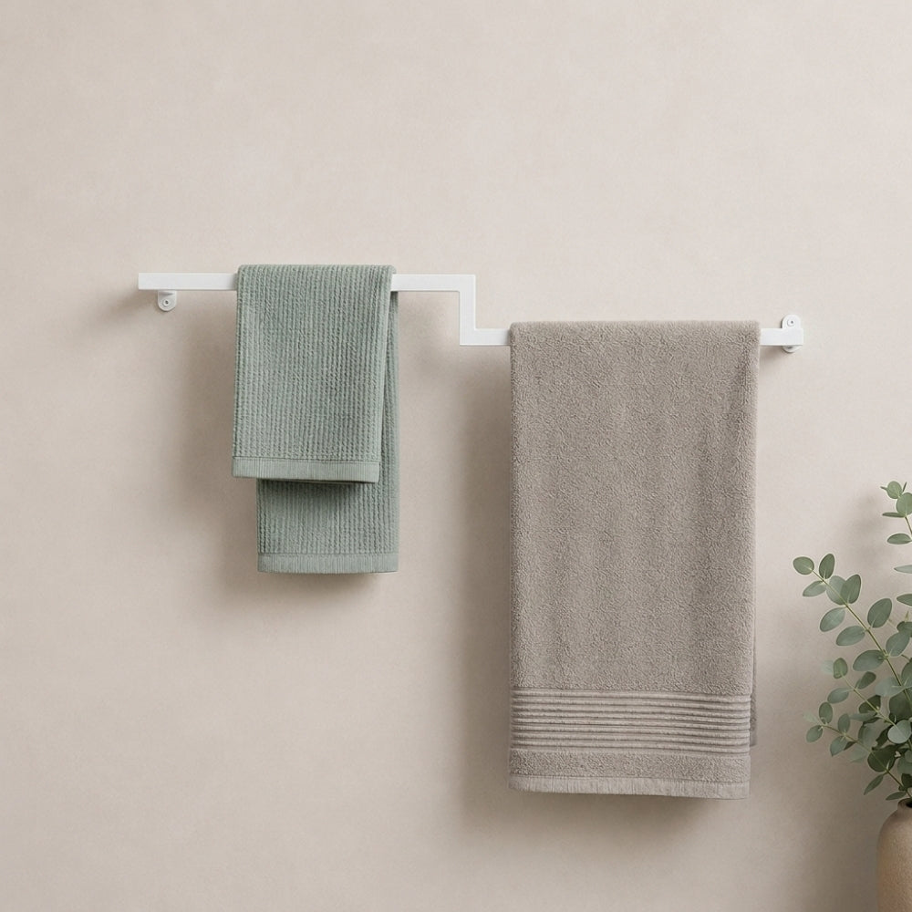 White wall mounted offset double towel bar holding mint and gray towels on a bathroom wall.