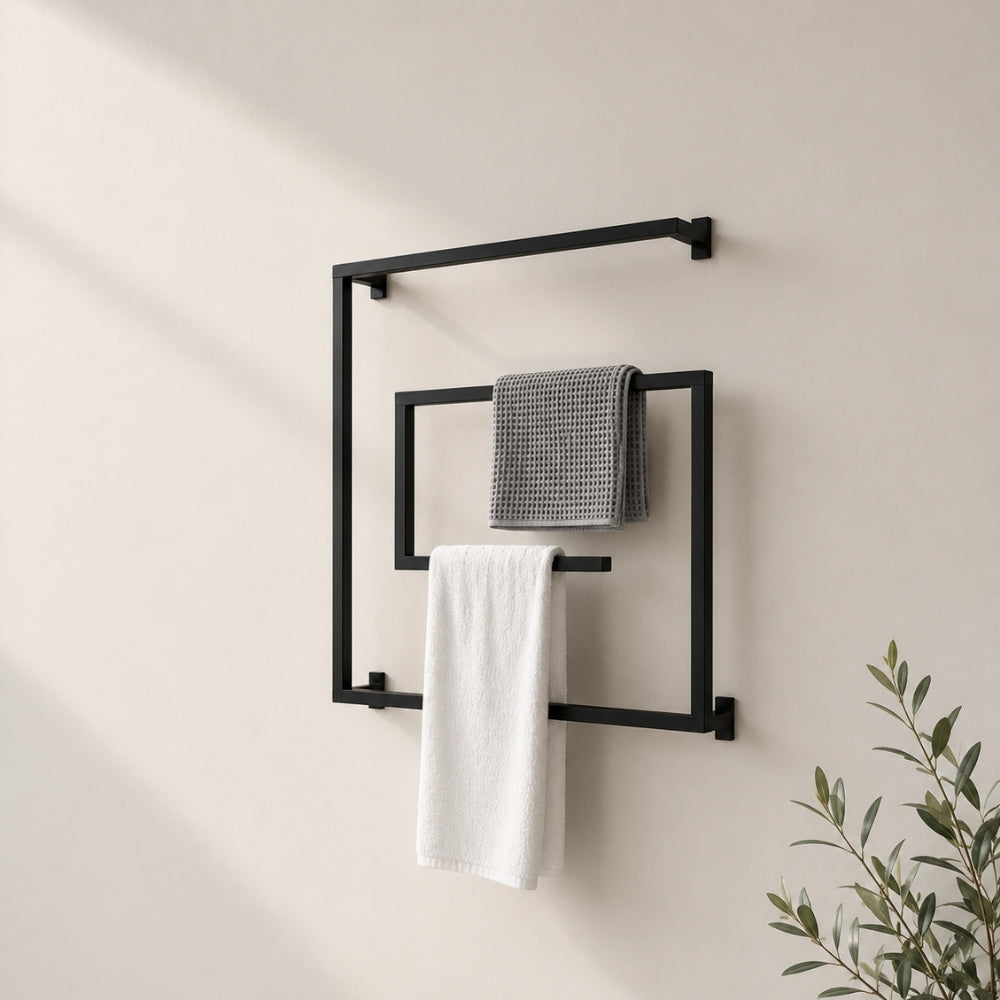 Black wall mounted square swivel towel rack holding gray and white towels on a bathroom wall.