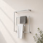 Satin nickel wall mounted square swivel towel rack holding gray and white towels on a bathroom wall.