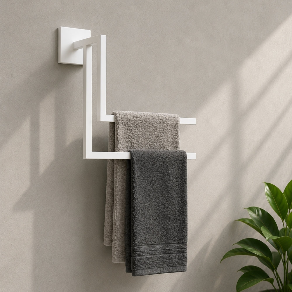 White wall mounted staggered towel rack holding gray towels on a bathroom wall.