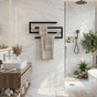 Black wall mounted swivel towel rack holding towels in a bright modern bathroom.