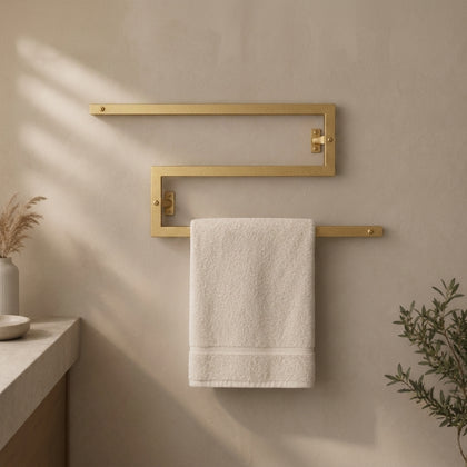 Gold wall mounted zigzag swivel towel rack holding a towel.