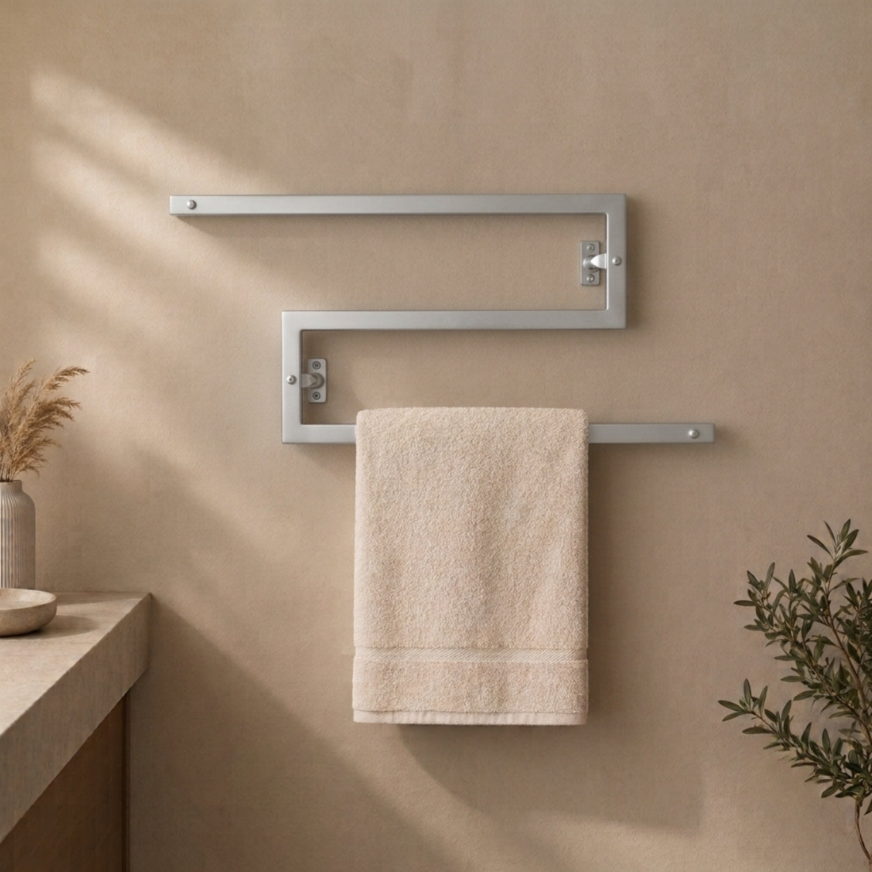 Satin nickel wall mounted zigzag swivel towel rack holding a towel.