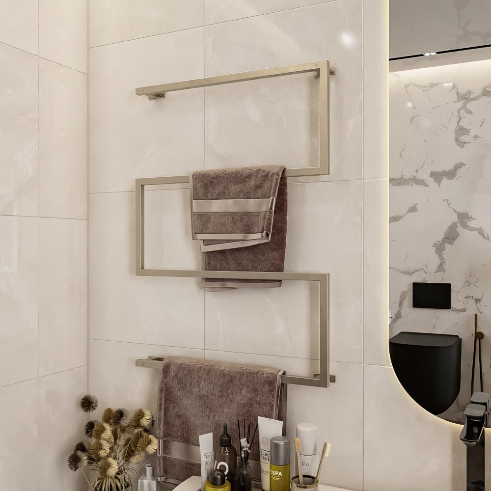 Wall-mounted towel holder in Satine Nickel finish, installed in a modern bathroom. The holder features a geometric design with multiple tiers for hanging towels. The backdrop includes a large bathtub, light-colored tiles, and a sleek toilet area, complementing the minimalist aesthetic.