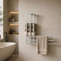 Satin nickel wall mounted towel rack with storage shelf holding rolled towels and a beige towel in a modern bathroom.