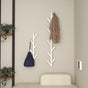 A modern entryway featuring wall-mounted, tree-shaped coat racks in white. The minimalist design adds a stylish touch, perfect for hanging coats and bags. The racks are positioned above a cozy beige bench, complemented by green potted plants for a welcoming and organized space.