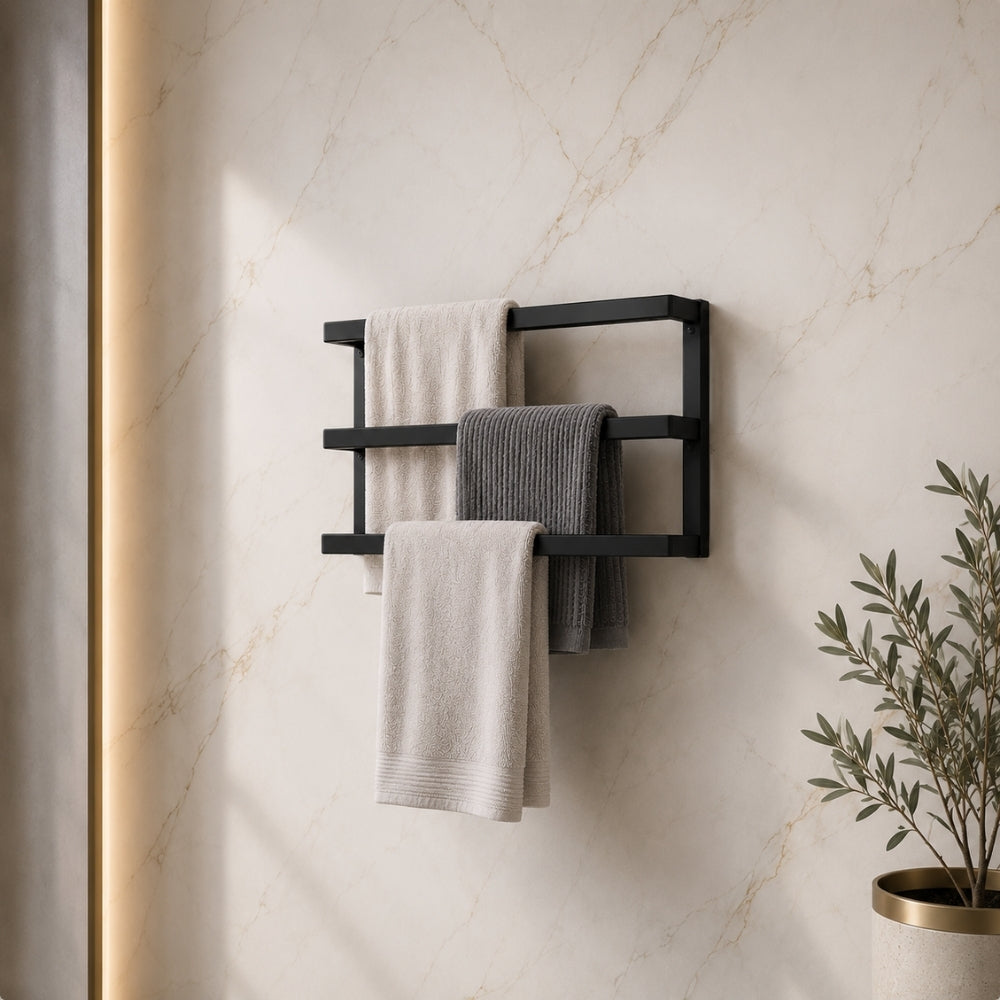 Black wall mounted triple towel bar rack holding three towels on a marble-look bathroom wall.