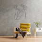 A white abstract metal wall art of a female figure with flowers displayed in a modern interior with a yellow accent chair and decorative items on a side table