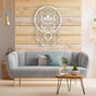White metal wall art of a wise owl dreamcatcher displayed on a wooden accent wall above a light blue sofa, styled with modern decor.